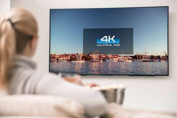 Big modern TV with 4k resolutions and young woman on foreground watching some video Big modern TV with 4k resolutions and young woman on foreground watching some video High-Definition Display screen stock pictures, royalty-free photos & images